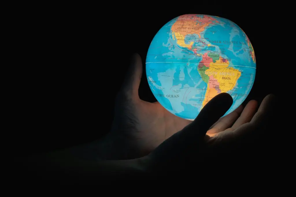 mains tenant une mappemonde